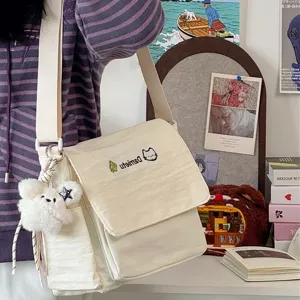 Casual canvas messenger bag for students, cute crossbody shoulder bag with fluffy bear pendant.