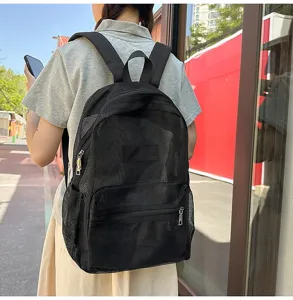 Vue détaillée du sac à dos en mesh noir porté en extérieur avec un tissu très respirant et léger.
