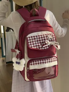 Detailed view of casual student backpack with plaid flap, bowknot, and clear window pocket.