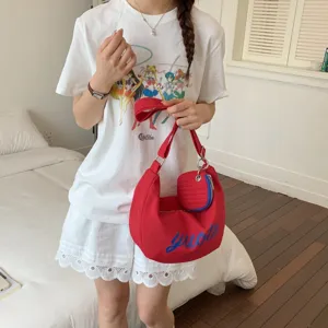 Red nylon hobo shoulder bag with attached round coin pouch, vibrant contrast street style details.