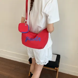 Red nylon crossbody bag with blue letter print and small pouch, casual everyday shoulder bag.