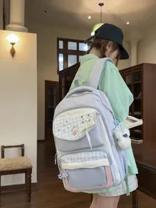 Detailed view of the stylish plaid student backpack showcasing cute embroidery and comfortable straps.