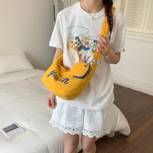 Yellow canvas crossbody bag with small pouch and chic youth letter print, casual style.