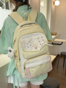 Detailed view of the cute plaid embroidered student backpack with ribbon and star charms.