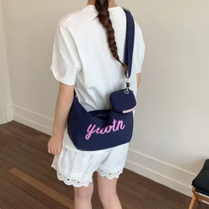 Dark blue canvas shoulder bag with pink youth letter print and cute mini pouch accessory.