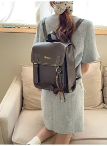 Close-up of the vintage dark brown PU leather backpack with fine stitching and hanging charm.