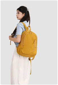 Side view of a stylish yellow travel backpack worn by a model, showing large capacity details.