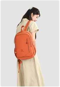 Close-up detail shot of casual orange waterproof backpack for women commute daily use travel.