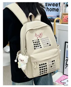 Beige canvas backpack for students, large capacity travel school bag with cute bear pendant.