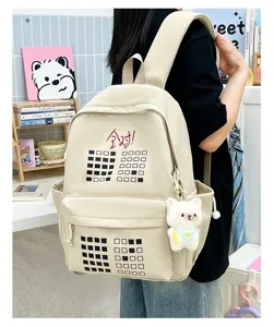 Detailed view of canvas backpack with grid pattern, cute bear plush pendant and chic print.