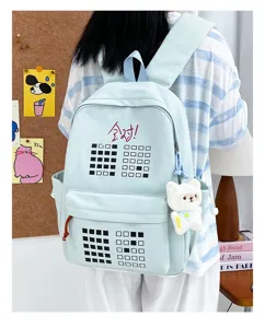 Detail view of light blue student backpack featuring grid pattern and cute plush bear charm.