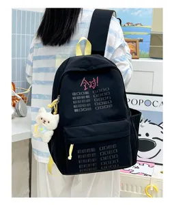Black canvas school backpack with cute cat pendant, spacious daily travel daypack for students.