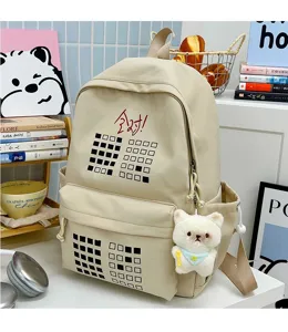 Canvas student backpack detail showcasing cute bear pendant, grid pattern and spacious capacity.