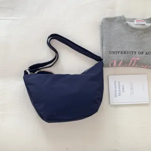 Detail view of the minimalist navy blue crossbody shoulder bag, featuring adjustable strap.