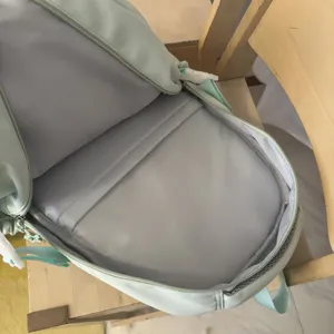 Light green student backpack main view showing spacious interior compartment and smooth zipper design.