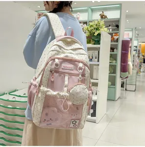 Vista detallada de una bonita mochila rosa de lunares estilo japonés con bolsillo frontal.