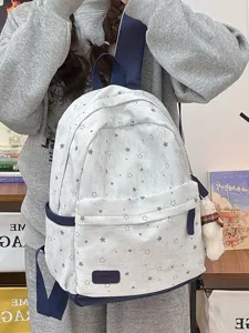 Detailed view of grey star pattern school backpack worn by model, showing fabric and pocket.