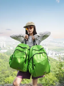 Detailed view of the vibrant green lightweight outdoor mountaineering backpack in use.