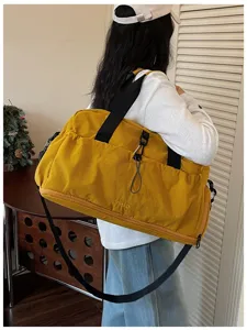 Large capacity yellow travel duffel bag detail showing shoulder strap and sporty design.