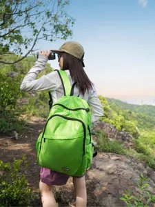 Detailed outdoor hiking scene featuring a vibrant light green lightweight travel backpack.