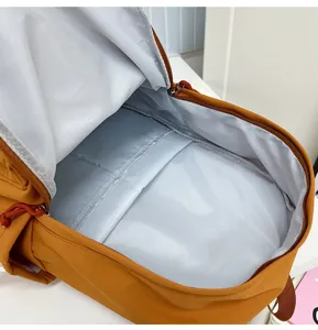 Close-up view of the spacious inner lining and compartment of a yellow travel backpack.
