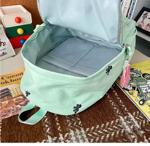 Mint green student backpack with cute animal embroidery, spacious interior detail view.