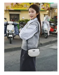 Casual canvas crossbody bag styled in street scene, featuring compact design for daily use.