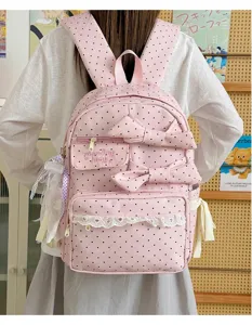 Sweet pink polka dot backpack detail showing bows, lace trim and soft fabric design.