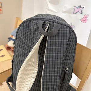 Detailed view of the dark grey grid backpack with white mesh straps, casual daily school bag.