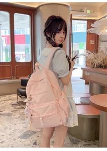 Detailed view of stylish pink student backpack with cute pendant, perfect for daily wear.