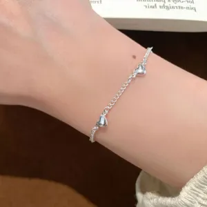 Delicate silver-tone chain bracelet featuring charming small heart pendants for daily wear.