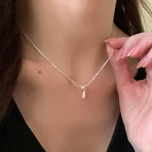 Detailed close-up of a sweet double-layer necklace featuring a delicate water drop pendant worn on.