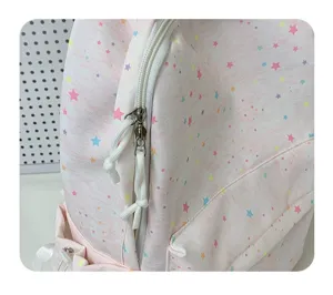 Close-up detail view of the pink star print backpack zipper and soft fabric texture surface.