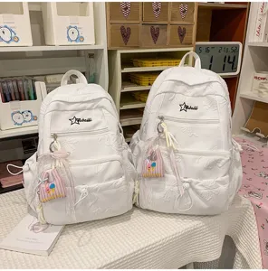 Detail view of white embossed school backpack with cute star logo and pendant for daily use.