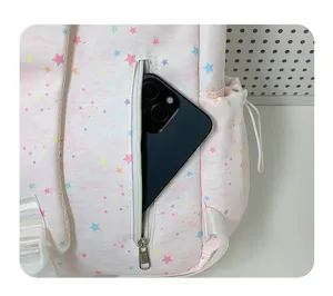 Pink star print backpack front pocket detail view, cute aesthetic student school bag.