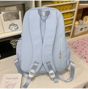 Light blue embossed backpack detail showing back straps and convenient zipper pocket