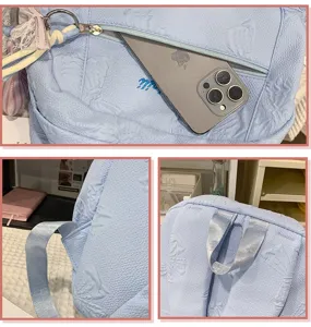 Detail view of light blue school backpack with embossed pattern front pocket and sturdy strap.