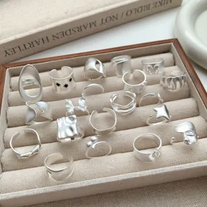 Primer plano de anillos plateados mate de tendencia con formas geométricas irregulares.