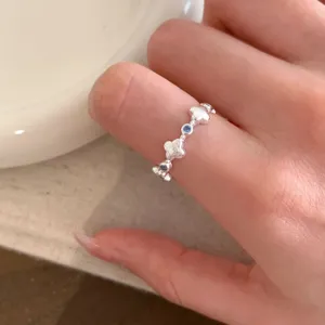 Exquisite silver clover ring with blue stones, minimalist open design for daily wear.