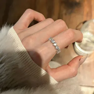 Close-up detail of the stylish star ring worn on finger, featuring sparkling stones.