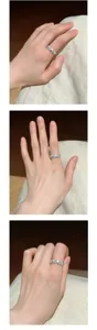Elegant detailed shot of a silver open ring with sparkling blue stones worn on finger.