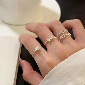 Detailed close-up of stackable silver rings featuring cute flower and butterfly design.