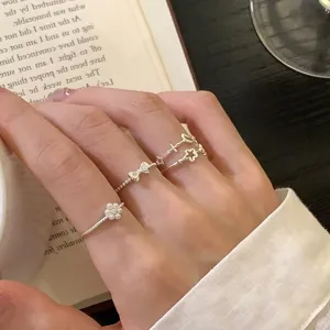 Exquisite stackable silver rings set featuring delicate bow, moon and floral design details.