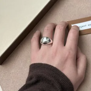 Detalle en primer plano de un elegante anillo abierto geometrico irregular plateado.
