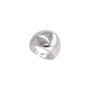 Primer plano de un anillo abierto de plata abombado y liso con diseño geométrico pulido.