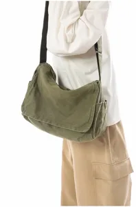 Casual olive green canvas messenger bag with wide strap and side pockets, durable daily use.