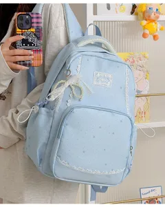 Detail shot of light blue star print backpack with delicate white lace trim and cute pearl pendant.