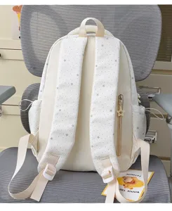 Detailed view of cream backpack with grey stars pattern, adjustable straps and cute zipper.