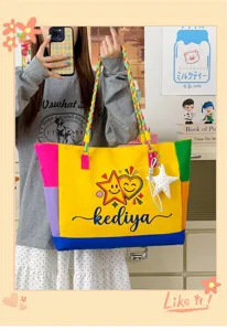 Detailed shot of vibrant color-blocked canvas tote bag with braided strap and cute charm.