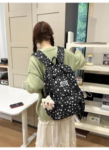 Black star print school backpack with cute star pendant for casual daily commuting.